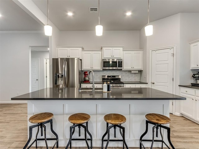 8512 NW 77th St, Oklahoma City, OK 73132 - kitchen with tasteful backsplash, dark countertops, visible vents, appliances with stainless steel finishes, and a sink