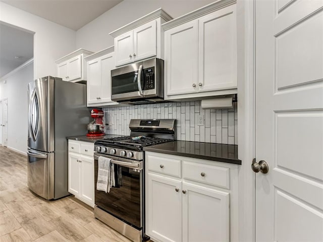 8512 NW 77th St, Oklahoma City, OK 73132 - kitchen with decorative backsplash, dark countertops, light wood-style floors, and stainless steel appliances