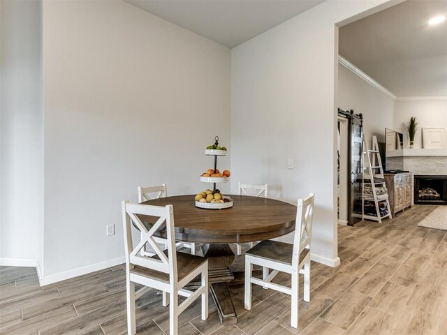 8512 NW 77th St, Oklahoma City, OK 73132 - dining room with ornamental molding, baseboards, light wood finished floors, and a barn door
