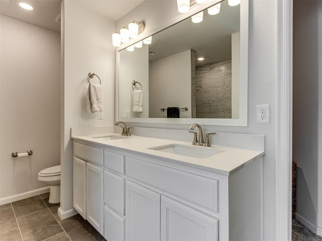 8512 NW 77th St, Oklahoma City, OK 73132 - bathroom with double vanity, baseboards, a sink, and toilet