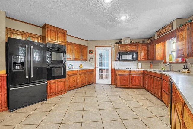 13989 US Highway 183, Hobart, OK 73651 - kitchen with black appliances, a sink, a textured ceiling, brown cabinetry, and light countertops
