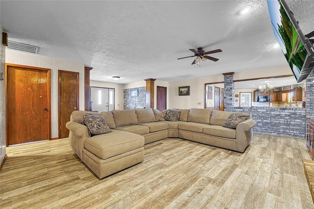 13989 US Highway 183, Hobart, OK 73651 - living area featuring a textured ceiling, ornate columns, light wood-type flooring, and ceiling fan