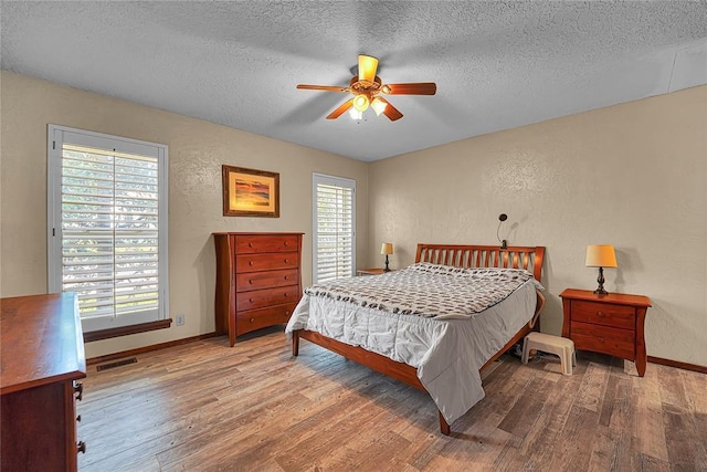 13989 US Highway 183, Hobart, OK 73651 - bedroom with a textured wall, a textured ceiling, wood finished floors, baseboards, and ceiling fan