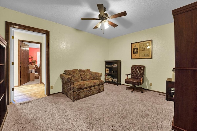 13989 US Highway 183, Hobart, OK 73651 - living area featuring carpet flooring, a ceiling fan, baseboards, a textured wall, and a textured ceiling