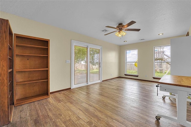 13989 US Highway 183, Hobart, OK 73651 - unfurnished living room with a ceiling fan, hardwood / wood-style floors, baseboards, and a textured ceiling