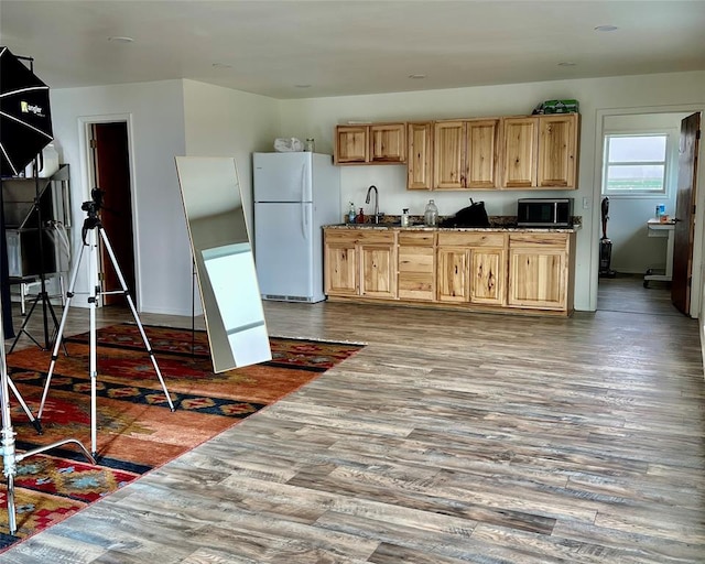 13989 US Highway 183, Hobart, OK 73651 - kitchen with freestanding refrigerator, black microwave, light brown cabinetry, and wood finished floors