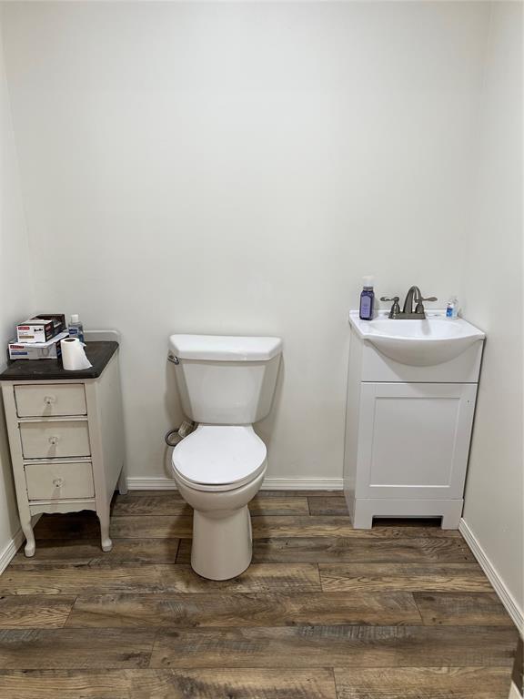 13989 US Highway 183, Hobart, OK 73651 - bathroom featuring vanity, wood finished floors, toilet, and baseboards