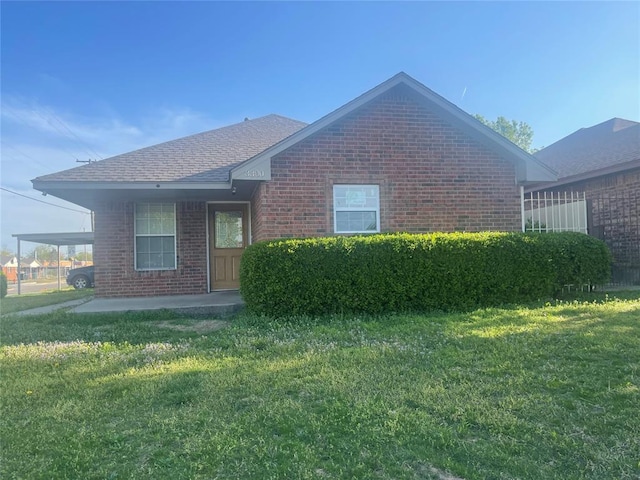 3300 SW 41st St, Oklahoma City, OK 73119 - view of front of house with an attached carport, brick siding, a shingled roof, and a front yard