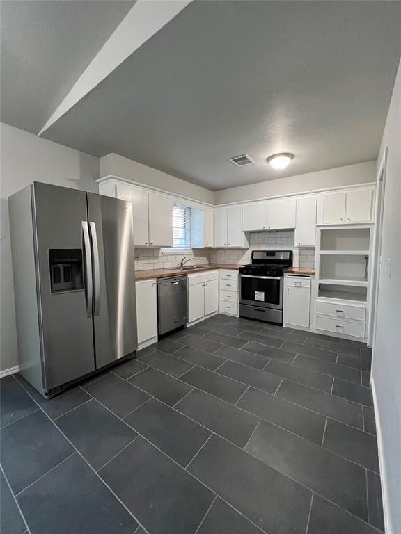 7440 NW 5th Ter, Oklahoma City, OK 73127 - kitchen featuring white cabinets, appliances with stainless steel finishes, backsplash, and visible vents