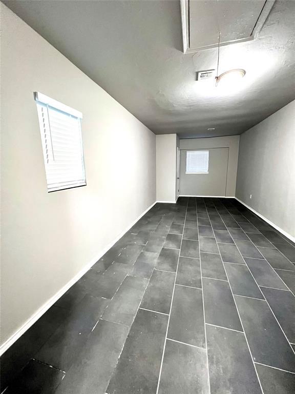 7440 NW 5th Ter, Oklahoma City, OK 73127 - unfurnished room with tile patterned floors, visible vents, baseboards, and attic access