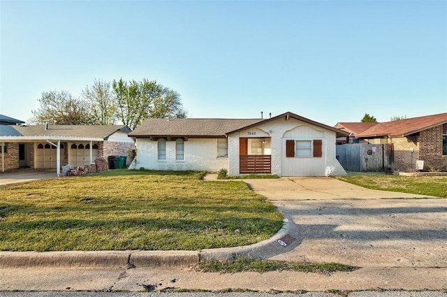 7440 NW 5th Ter, Oklahoma City, OK 73127 - ranch-style house with concrete driveway, fence, a front lawn, and brick siding