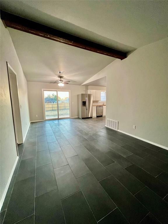 7440 NW 5th Ter, Oklahoma City, OK 73127 - unfurnished living room with dark tile patterned floors, baseboards, visible vents, ceiling fan, and vaulted ceiling with beams