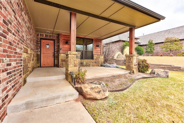 view of exterior entry with stone siding and a porch