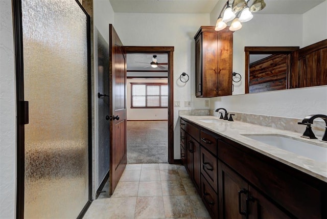bathroom with double vanity, a sink, baseboards, and a shower stall