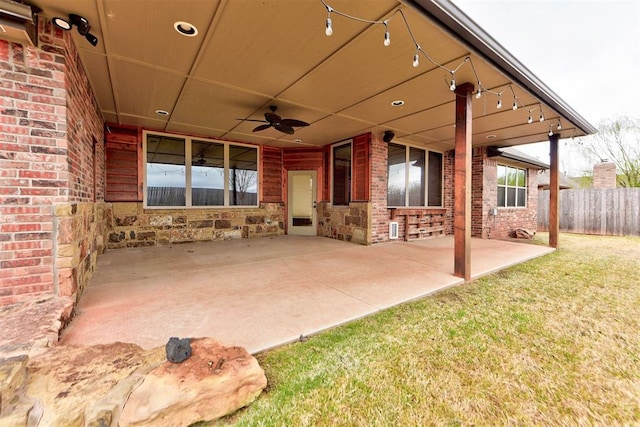 view of patio with ceiling fan and fence