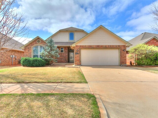 traditional-style home with an attached garage, concrete driveway, a front yard, brick siding, and roof with shingles