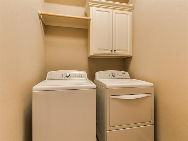 clothes washing area with cabinet space and washer and dryer