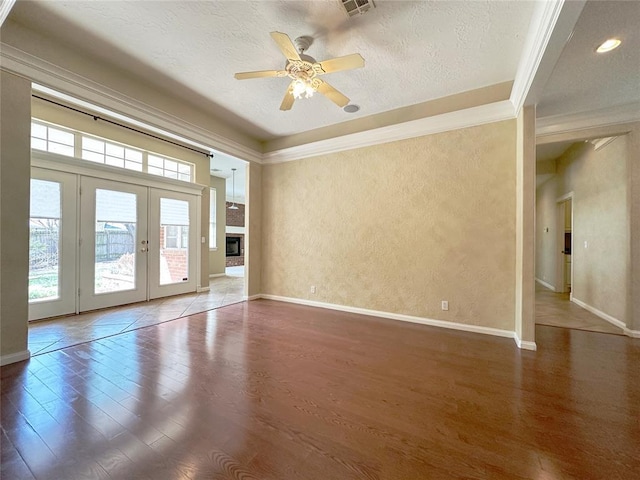 4000 Harrogate Dr, Norman, OK 73072 - unfurnished room with a textured ceiling, ornamental molding, wood finished floors, and french doors