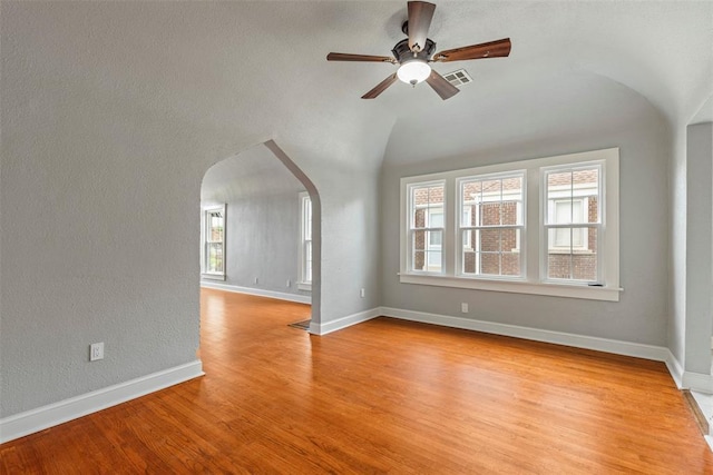 923 NE 19th St, Oklahoma City, OK 73105 - empty room featuring ceiling fan, arched walkways, vaulted ceiling, light wood-style flooring, and baseboards
