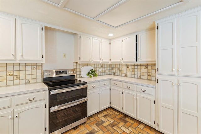 57 Serenada Ln, Shawnee, OK 74804 - kitchen with range with two ovens, brick patterned flooring, white cabinets, light countertops, and backsplash