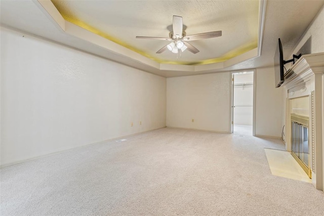 57 Serenada Ln, Shawnee, OK 74804 - unfurnished living room featuring a tray ceiling, a ceiling fan, light carpet, baseboards, and a textured ceiling