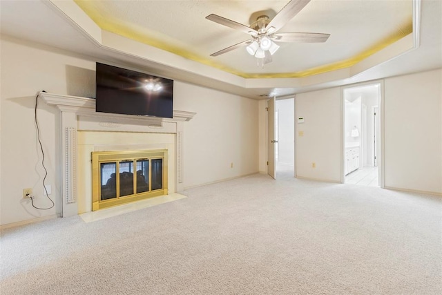 57 Serenada Ln, Shawnee, OK 74804 - unfurnished living room featuring a raised ceiling, ceiling fan, carpet flooring, a high end fireplace, and baseboards