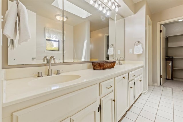 57 Serenada Ln, Shawnee, OK 74804 - bathroom featuring a skylight, double vanity, tile patterned floors, baseboards, and a closet