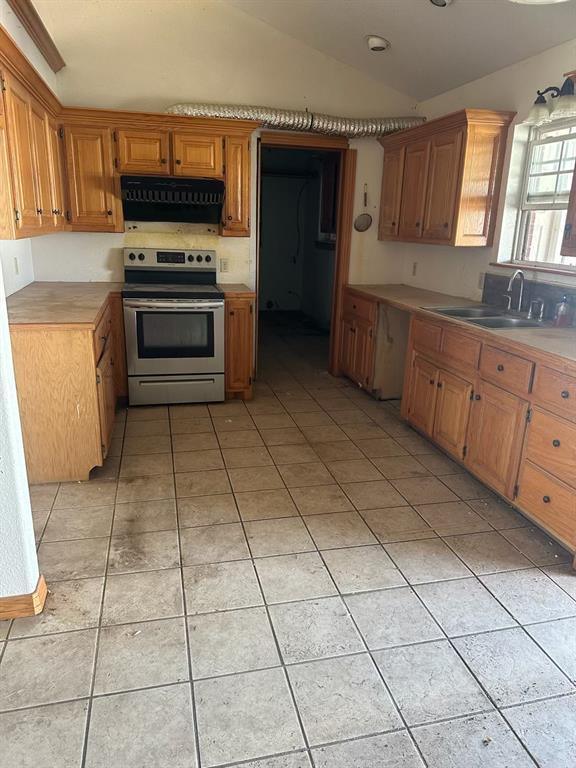 kitchen with light tile patterned flooring, lofted ceiling, a sink, extractor fan, and stainless steel electric stove