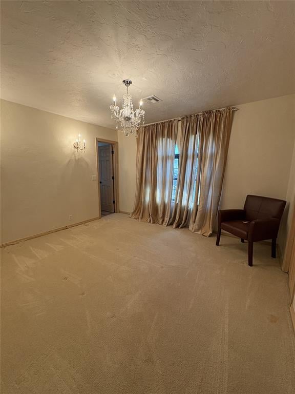 9721 N Lakeland Rd, Oklahoma City, OK 73162 - empty room featuring visible vents, a notable chandelier, light carpet, and a textured ceiling