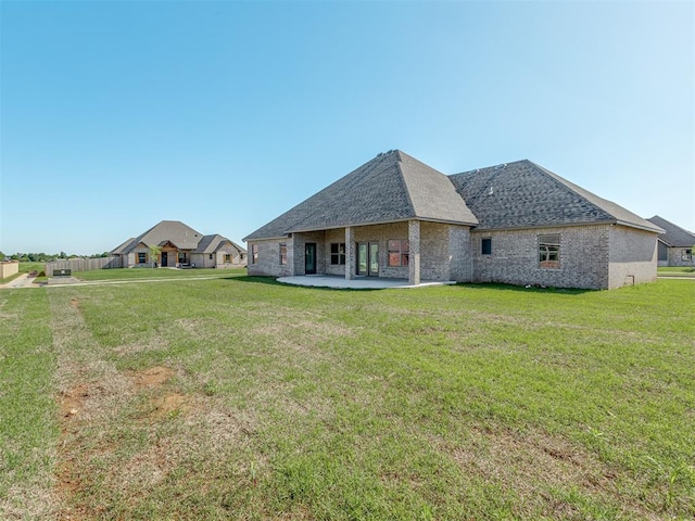 1209 Jozie Way, Tuttle, OK 73089 - rear view of property with roof with shingles, a yard, a patio area, and brick siding