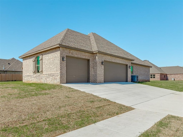 1209 Jozie Way, Tuttle, OK 73089 - view of front of property featuring driveway, brick siding, a front lawn, an attached garage, and a shingled roof