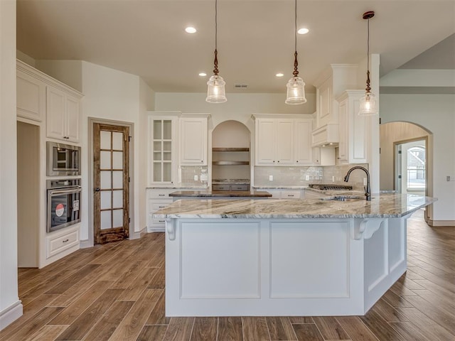 1209 Jozie Way, Tuttle, OK 73089 - kitchen with arched walkways, a sink, appliances with stainless steel finishes, and decorative backsplash