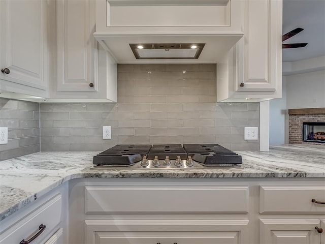 1209 Jozie Way, Tuttle, OK 73089 - kitchen featuring light stone counters, white cabinetry, stainless steel gas stovetop, and tasteful backsplash