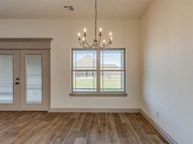 1209 Jozie Way, Tuttle, OK 73089 - unfurnished dining area featuring french doors, visible vents, an inviting chandelier, and dark wood-type flooring