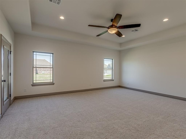 1209 Jozie Way, Tuttle, OK 73089 - empty room featuring a ceiling fan, a tray ceiling, light colored carpet, and visible vents