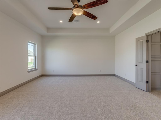 1209 Jozie Way, Tuttle, OK 73089 - spare room with a ceiling fan, baseboards, light carpet, and a tray ceiling