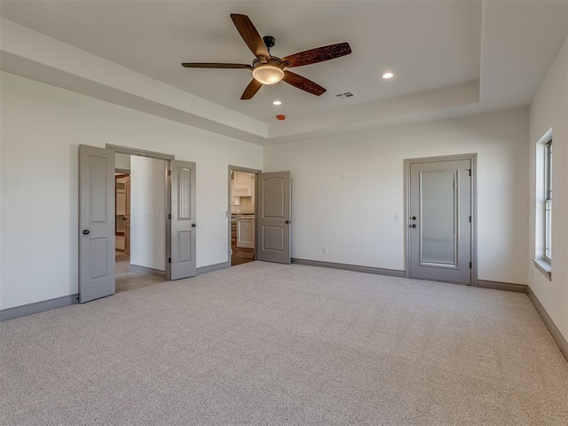 1209 Jozie Way, Tuttle, OK 73089 - unfurnished bedroom featuring visible vents, baseboards, light colored carpet, and a raised ceiling
