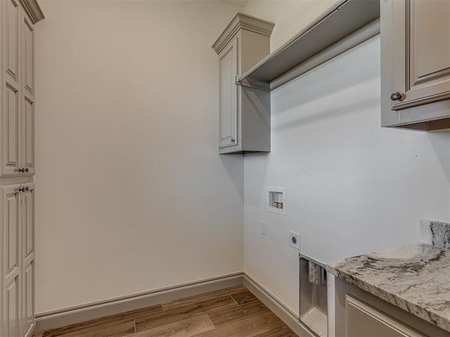 1209 Jozie Way, Tuttle, OK 73089 - clothes washing area featuring cabinet space, hookup for a washing machine, electric dryer hookup, baseboards, and wood finished floors