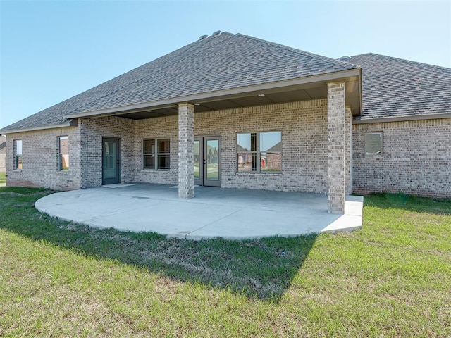 1209 Jozie Way, Tuttle, OK 73089 - back of property with brick siding, a shingled roof, a lawn, and a patio area