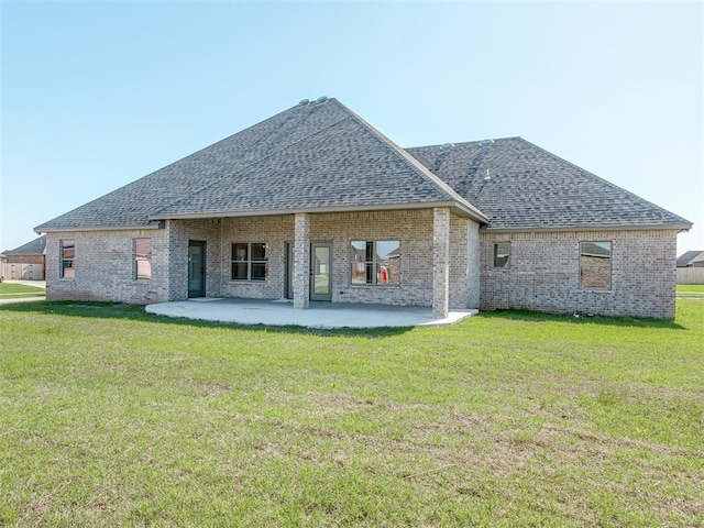 1209 Jozie Way, Tuttle, OK 73089 - back of property with brick siding, roof with shingles, a patio area, and a yard