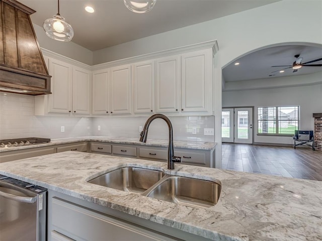 1212 Jaden Blvd, Tuttle, OK 73089 - kitchen with a sink, cooktop, light stone counters, ceiling fan, and white cabinetry