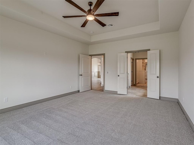 1212 Jaden Blvd, Tuttle, OK 73089 - unfurnished bedroom with light carpet, baseboards, a raised ceiling, and arched walkways