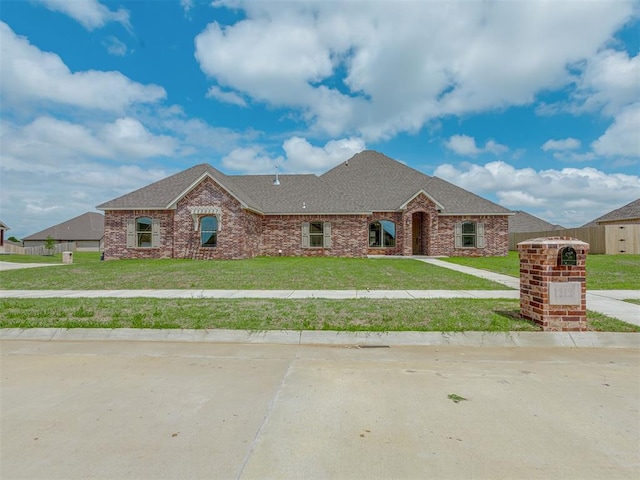 1212 Jaden Blvd, Tuttle, OK 73089 - view of front of property with a front lawn, a shingled roof, and brick siding