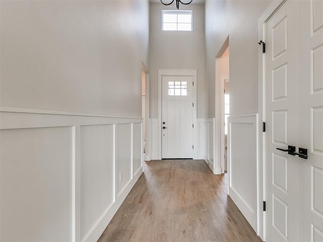 entrance foyer with a wainscoted wall and light wood finished floors