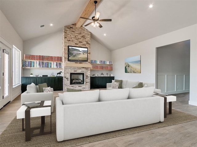 living area featuring wood finished floors, high vaulted ceiling, beam ceiling, and ceiling fan