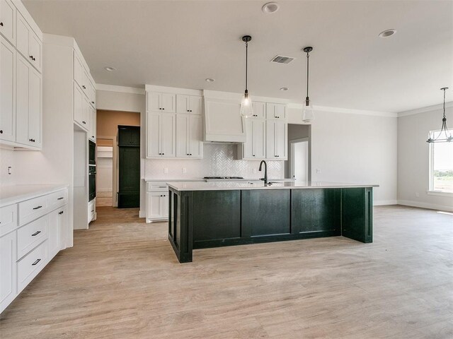 kitchen featuring white cabinetry, visible vents, and tasteful backsplash