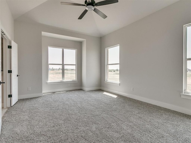 empty room featuring baseboards, lofted ceiling, ceiling fan, and carpet floors