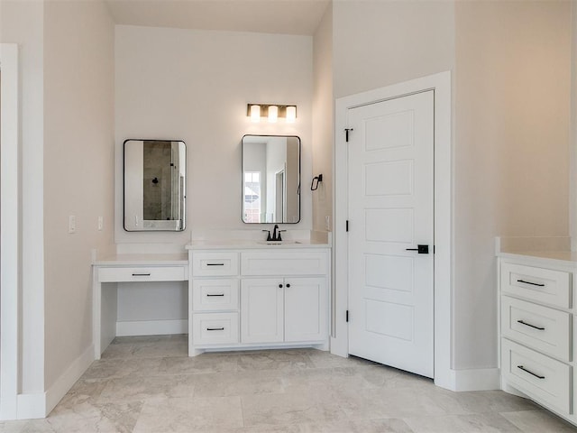 bathroom with vanity, baseboards, and tiled shower