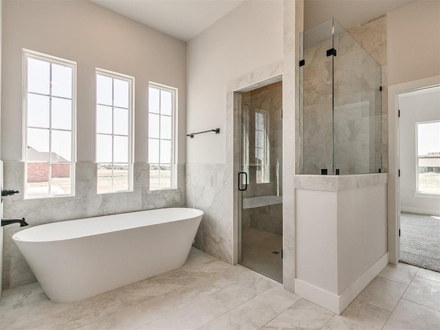 bathroom featuring a wainscoted wall, a freestanding tub, and a shower stall
