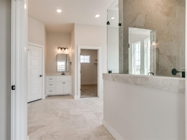 full bathroom featuring walk in shower, baseboards, recessed lighting, vanity, and a walk in closet